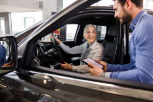 Senhora comprando um carro 0 km e o vendedor de carros ao seu lado