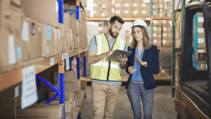 Uma gerente e um supervisor de logística e transporte fazendo check up de cargas.