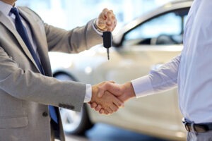homem passando a chave do seu carro para o outro que pediu emprestado