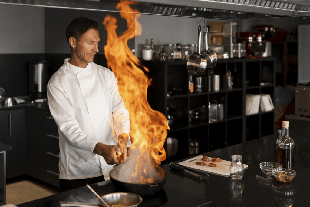 Cozinheiro fazendo prato com a panela lançando uma grande labareda