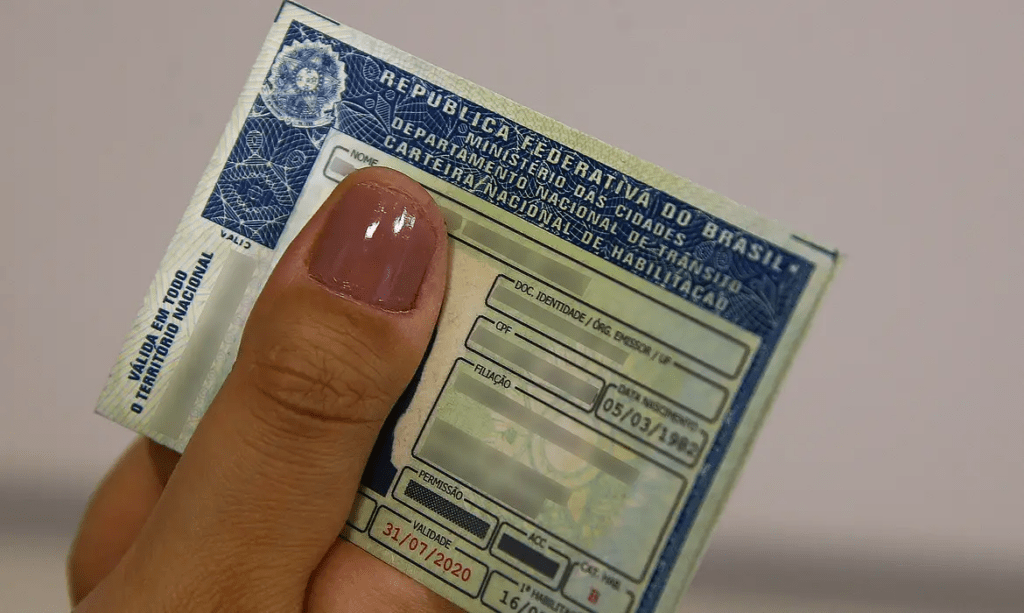 Mão segurando uma CNH