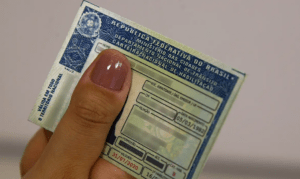 Mão segurando uma CNH
