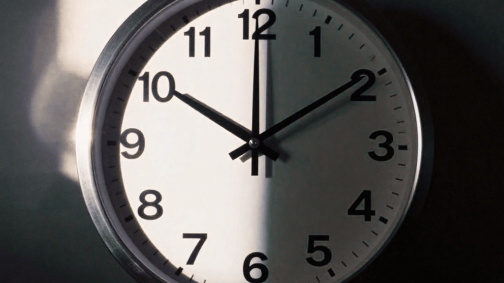 Um relógio, metade de dia metade a noite