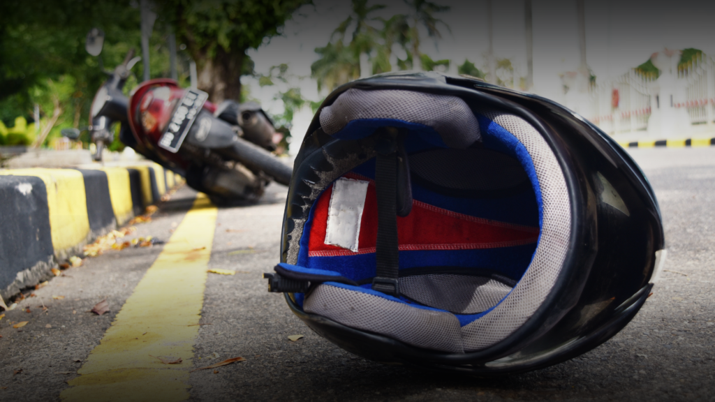 moto tombada e capacete no chão