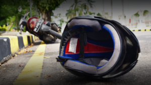 moto tombada e capacete no chão