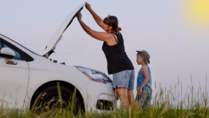 Uma mãe e seu filho no meio da estrava vendo o carro que deu problema