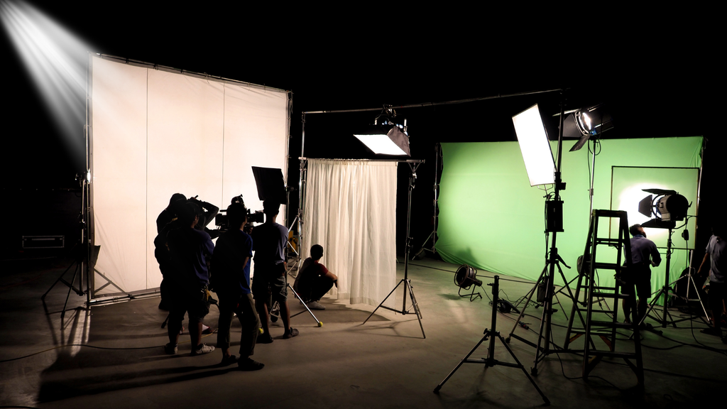 Técnicos de Câmera, Luz e Som operando dentro de um set de filmagens