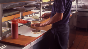 Funcionário de restaurante montando um lanche