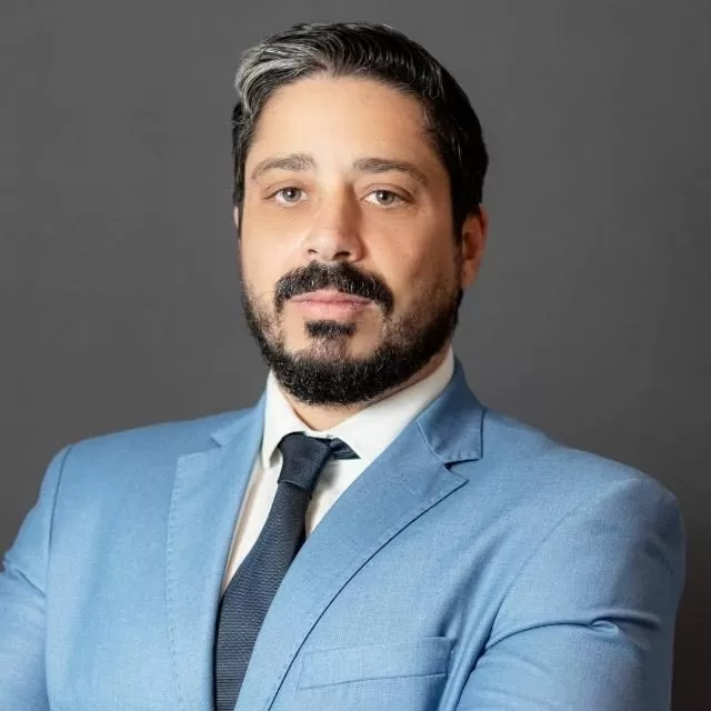 Dr. Eduardo Dias Djamdjian de terno azul e fundo cinza